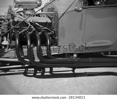 The exposed engine and exhaust pipes of a hot rod.