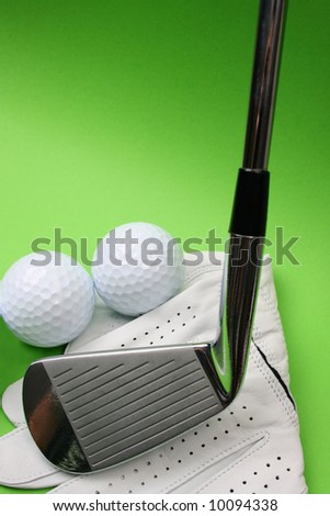 Golf glove, club and balls on a green background