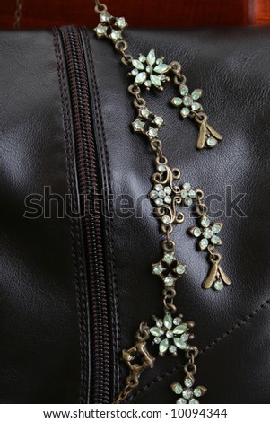 Green gemstone necklace against brown leather boots
