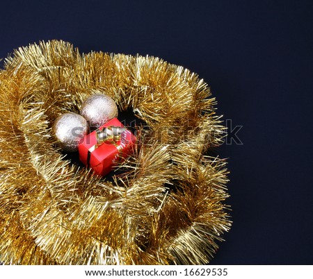 Small Christmas gift circled by gold tinsel string