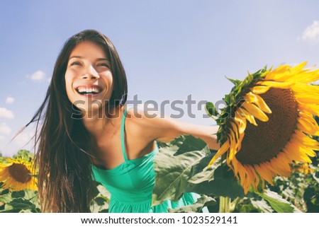 Spring flower field nature woman happy allergy-free breathing clean air in summer sunshine. Pollen allergies concept. Asian smiling girl portrait. Outdoors lifestyle happiness.