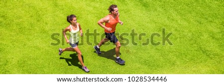 Runners running people couple fitness banner. Healthy active lifestyle. Active couple jogging together on grass park view from above. Summer weight loss training program.