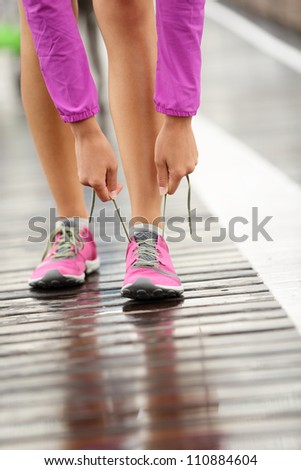 Running shoes Barefoot running shoes closeup Woman tying laces before jogging in minimalistic barefoot running shoes on Brooklyn Bridge New York USA. Running shoes Barefoot running shoes closeup Woman tying laces before jogging in minimalistic barefoot running shoes on Brooklyn Bridge New York USA.