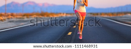 Road runner female athlete running shoes training on desert road banner. Panorama crop of lower body jogging outdoors at sunset.