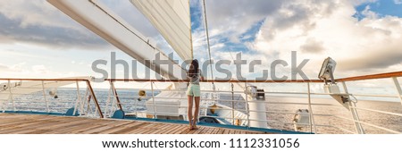 Luxury cruise ship vacation woman on deck banner panorama. Travel in Tahiti on sail boat, exotic destination. Tourism in oceania. Boat sailing away on tropical getaway