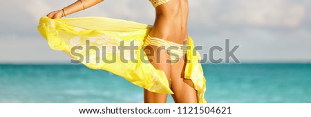 Bikini woman with yellow scarf unveiling toned slim thighs and body. Spa wellness free happy girl in bikini weight loss healthy living concept. Panorama banner.