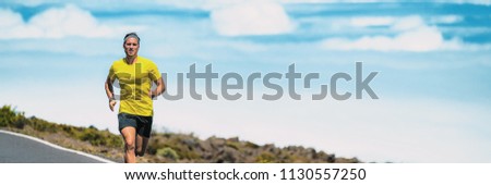 Runner man running on triathlon marathon race outdoors in summer heat. Male athlete training cardio running long distance outside. Banner panorama.