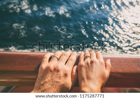 Cruise travel honeymoon married couple. Newlyweds woman and man with wedding bands rings on ship deck.