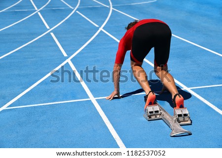Runner ready to run on running track start line. Sport athlete going sprinting towards success on blue tracks. Sprinter on competition race challenge at stadium.