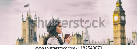 London travel woman drinking coffee cup by Big Ben Westminster in cold morning fall. Asian tourist girl pensive looking at view banner panorama.