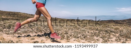 Sport exercise fitness female athlete runner running on trail run race in desert panorama banner. Closeup of legs and running shoes.