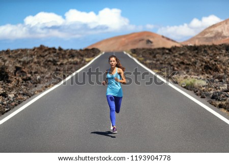 Athlete runner fit woman running on road in nature landscape. Fitness active healthy lifestyle Asian girl sprinting fast outside. Sport exercise concept.