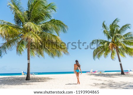 Caribbean beach in Barbados, bikini woman relaxing on Dover beach summer travel destination. Landscape with palm trees, tourist walking enjoying sun.