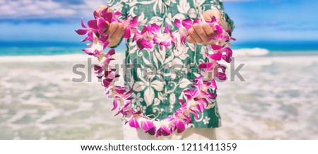 Hawaii welcome hawaiian lei flower necklace offering to tourist as welcoming gesture for luau party or beach vacation. Polynesian tradition.