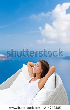 Sleeping woman relaxing in outdoor sofa chair on luxury cruise ship balcony or hotel home wellness outside resting area. Asian girl lying back dreaming.