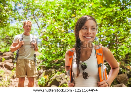 Forest hiker young hikers tourist walking in outdoor nature in Hawaii. Summer outdoor active lifestyle trek in Hawaii. Young Asian hiker girl, Caucasian man with backpacks.