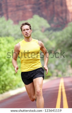 Sport - running fitness man sprinting training for marathon run. Fitness man with determination, concentration and strength training towards goals and success.