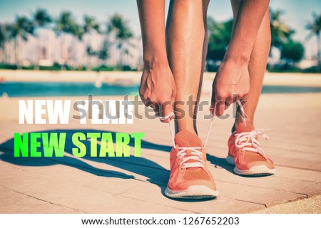 New Year New Start fitness new year resolution runner woman tying up laces of running shoes getting ready to run for weight loss. Athlete on summer beach