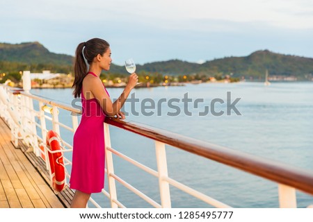 Luxury cruise ship honeymoon vacation woman drinking wine during dinner at outdoor restaurant deck of sailing boat in Tahiti, French Polynesia. Elegant lady drinking wine on balcony watching sunset.