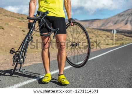 Bike repair cyclist man on side of road repair road bicycle problem with wheel. Cycling outdoor athlete biker biking with cycle.