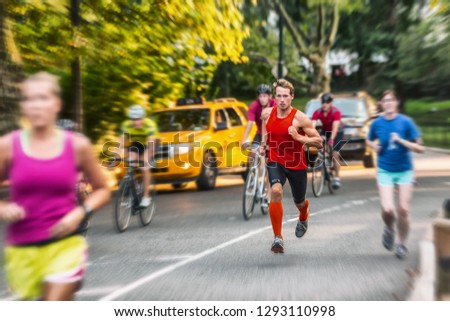 Runner athlete man running in run marathon race in Central Park New York city. People crowd jogging in street urban active lifestyle. Motion blur focus on one person.