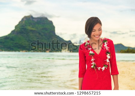 Bora Bora luxury vacation beautiful Asian tourist woman on Tahiti French Polynesia cruise ship travel adventure. Girl smiling wearing lei flower necklace on sunset beach walk.