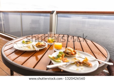 Cruise ship room balcony breakfast plates with fruits and eggs eaten. Real candid snapshot of half eaten food finished meals in the morning on Alaska travel.
