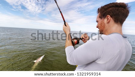 Shark fishing big game spinner shark biting bait man fisher reeling in animal in catch and release sports activity on water. Boat tour.