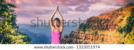 Yoga retreat in Kauai nature panoramic banner. Asian girl practicing meditation outdoors in sunset sitting with praying hands overhead for tree pose.