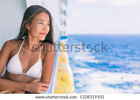 Cruise ship vacation bikini woman relaxing on deck. Asian girl in swimwear enjoying ocean view from boat in Caribbean travel holidays.