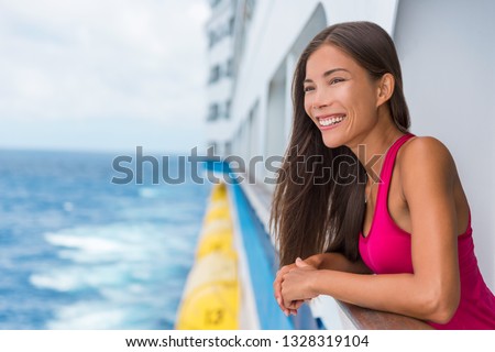 Happy Asian travel tourist woman relaxing on cruise ship deck enjoying summer Europe destination vacation cruising on sea.