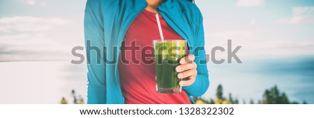 Green juice smoothie healthy drink breakfast shake. Woman drinking weight loss food diet banner panorama. Hand holding cold beverage glass.