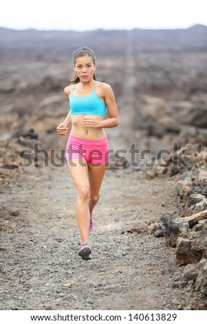 Healthy lifestyle runner woman trail running cross country running outdoors on volcano. Female athlete jogging training for marathon run outside in beautiful landscape on Big Islands, Hawaii, USA.