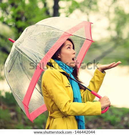 Umbrella Woman In Autumn Excited Under Rain On Fall Day.Beautiful Young Female Wearing Raincoat Surprised And Excited In The Rain. Mixed Race Asian Caucasian Girl In Her 20s Walking In Forest.