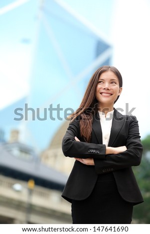 Asian business woman confident outdoor in Hong Kong standing proud in suit cross-armed in business district. Young mixed race female Chinese Asian / Caucasian female professional in central Hong Kong.