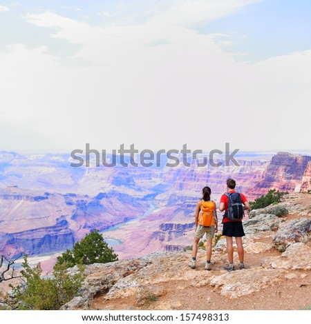 Grand Canyon - people hiking looking at view. Hiker couple walking on South Rim trail of Grand Canyon, Arizona, USA. Beautiful american landscape.
