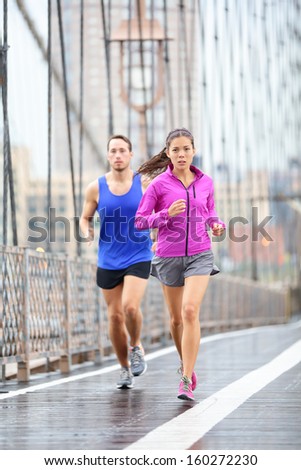Running couple Runners jogging outside in rain Woman and man runner athletes training outdoor for marathon on Brooklyn Bridge New York City USA Asian female and Caucasian male fitness sport model Running couple Runners jogging outside in rain Woman and man runner athletes training outdoor for marathon on Brooklyn Bridge New York City USA Asian female and Caucasian male fitness sport model