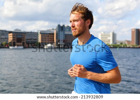 Man running in Copenhagen city. Danish male runner jogging in Bryggen, Copenhagen, Denmark.