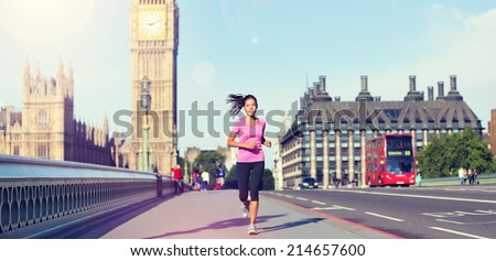London lifestyle woman running near Big Ben. Female runner jogging training in city with red double decker bus. Fitness girl smiling happy on Westminster Bridge, London, England, United Kingdom.
