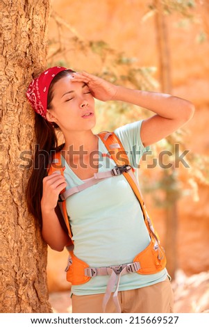 Dehydration thirst heat stroke exhaustion concept with woman hiker tired, dehydrated and exhausted Bryce Canyon. Girl tired close to heat stroke due to high temperature and lack of water.