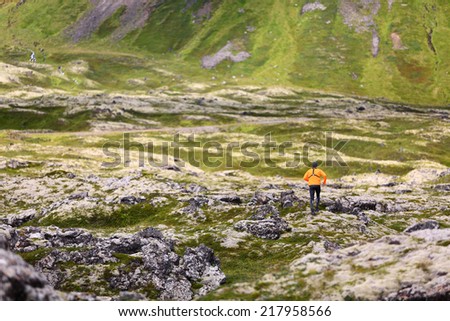 Trail running man in nature landscape doing cross country run. Fit male runner training jogging outdoors in beautiful mountain nature landscape with Snaefellsjokull, Snaefellsnes, Iceland.