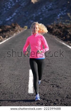 Running runner woman sport workout on mountain road. Jogging female fitness girl working out training for marathon on road in amazing nature landscape wearing warm clothing and running shoes.