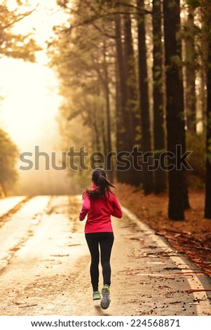 Athlete running on road in morning sunrise training for marathon and fitness. Healthy active lifestyle woman exercising outdoors.
