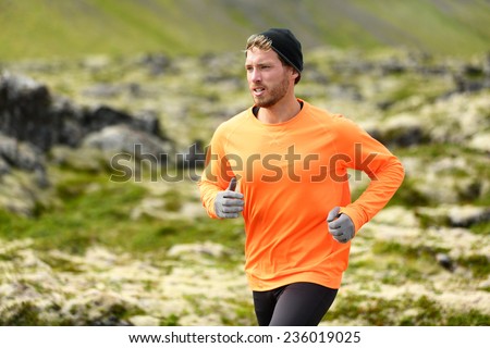 Runner. Sport running man in cross country trail run. Male athlete exercising and training outdoors in beautiful mountain nature landscape.
