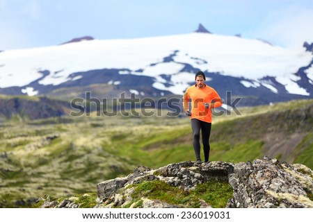 Running man exercising - trail runner athlete. Fit male sport fitness model training and jogging outdoors living healthy lifestyle in beautiful mountain nature, Snaefellsjokull, Snaefellsnes, Iceland.