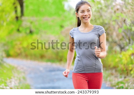 Woman nordic speed power walking, jogging and running lightly in forest in spring or summer. Sport fitness girl sports training and working out living healthy active lifestyle in forest.