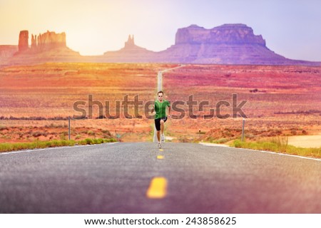 Runner man athlete running sprinting on road by Monument Valley. Concept with sprinter fast training for success. Fit sports fitness model working out in amazing landscape nature. Arizona, Utah, USA.