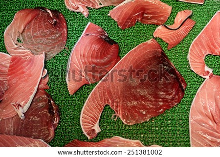 Raw tuna meat fillets or slices display in Tsukiji fish market, Tokyo, Japan. Famous touristic attraction selling raw seafood in the morning.