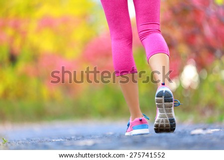 Jogging and running woman with athletic legs on jog or run on trail in forest in healthy lifestyle concept with close up on running shoes. Female athlete jogging and training outdoors in autumn fall.