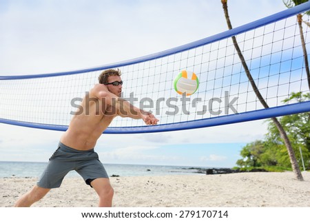Beach volleyball man playing forearm pass hitting volley ball during game on summer beach. Male model living healthy active lifestyle doing sport on beach.